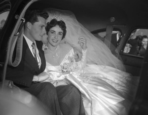 Actress Elizabeth Taylor and her groom, Conrad "Nickie" Hilton, Jr. in the limousine that will take them to their wedding reception at the Bel-Air Country Club, following their marriage at the Church of the Good Shepherd in Beverly Hills.