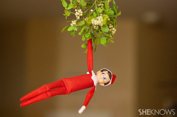 Elf on the Shelf idea 22: Elfie Rojo hanging under the mistletoe