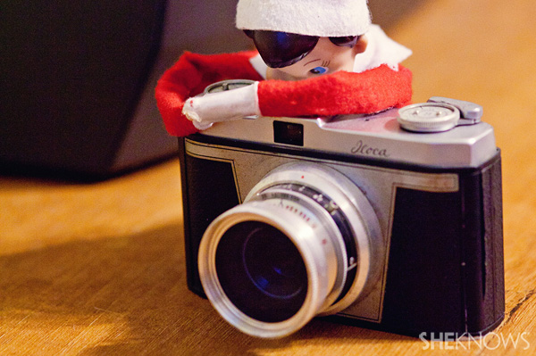 Elf on the Shelf idea 23: Elfie Rojo taking photographs